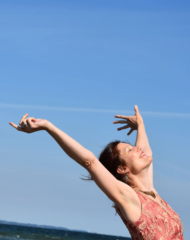 Antje Kammeyer wirft vor blauem Himmel jubelnd die Arme in die Luft.